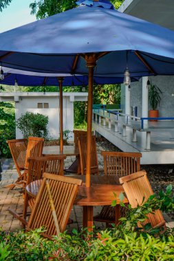 Bahçe sandalyelerini ve şemsiyeli masayı kapat. 
