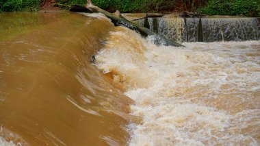 Sınır barajının ötesine hızla akan bulanık suyun oyalanmasına yakın görünüyor..