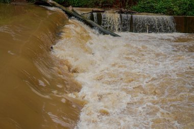 Sınır barajının ötesine hızla akan bulanık suyun oyalanmasına yakın görünüyor..