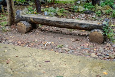 Şehir parkındaki ahşap bar şeklinde betondan yapılmış park bankı..