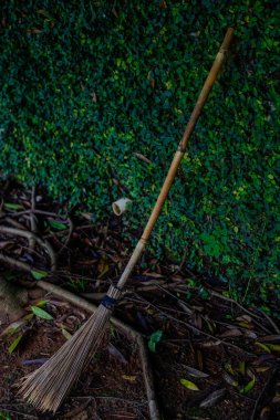 Duvardaki asmalara dayanan bir süpürgenin yakın çekim görüntüsü..