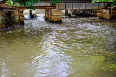 Su akan nehir köprünün altından hızla akıyor.