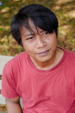 Kırmızılı yakışıklı adam aşağıya bakıyordu ve gülümsüyordu..