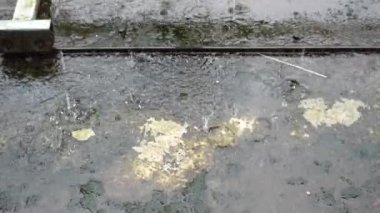 Beton zemine düşen yağmur damlaları paslı eski demir penseyle aşınmaya başlıyor..