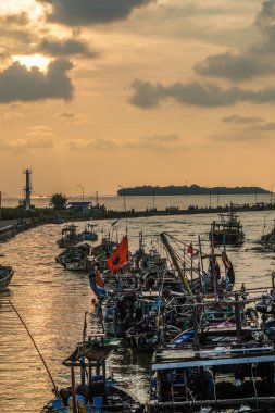 Jepara, Central Java, 7 Nisan 2024 - Jepara balıkçı tekneleri kalabalık bir limana park etti akşam gökyüzünün arka planına doğru boş bir reklam alanı ile