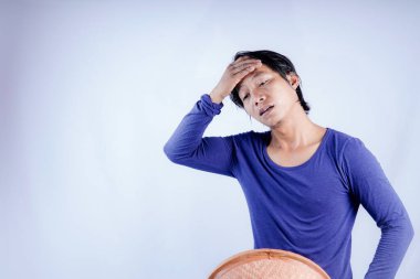 Elleriyle örülmüş bambu şapkasını tutan Cava 'lı adam alnını nazikçe siliyor, beyaz arka plan ve reklam için boş alan..