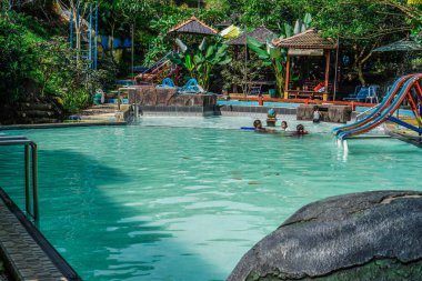 Yüzme havuzunun güzel manzarası. İçinde barınacak küçük evleri olan aileler var..