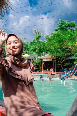 Yüzme havuzunda rahatça oturan Müslüman bir kadının yakın plan görüntüsü..