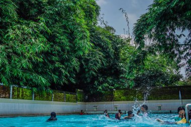 Jepara, Central Java, 14 Nisan 2024 - Ağaçlarla çevrili yüzme havuzu turları tatillerde ziyaretçilerle doludur.