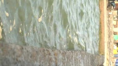 Deniz dalgalarının deniz kenarındaki baraja vurduğu yakın görüntü. Yükselen deniz suyu kavramı.