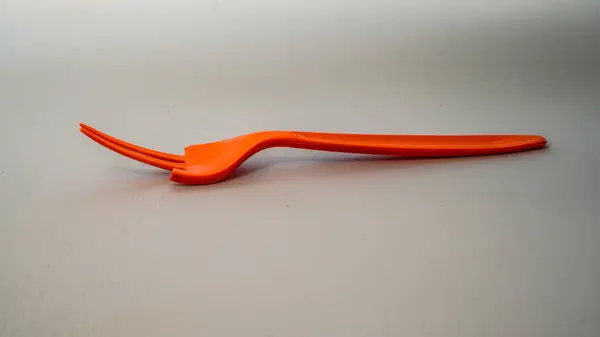 Kırık turuncu plastik çatal beyaz üzerine izole edilmiş ve reklam için boş alanı var..