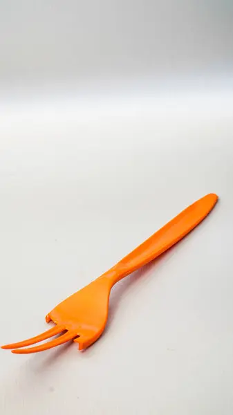 Kırık turuncu plastik çatal beyaz üzerine izole edilmiş ve reklam için boş alanı var..