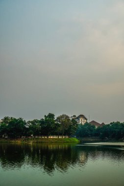 Sakin suyla gölün güzel manzarası, akşam gökyüzünün arka planı ve reklam için boş bir alan..