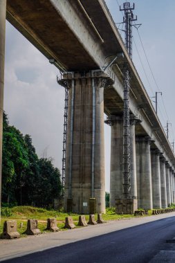 Beton destekli bir elektrikli tren yolunun alt görünümü, kopyalama alanı olan gökyüzü arkaplanı.