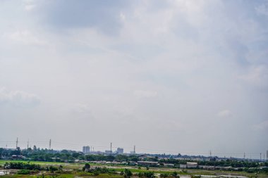 Gökyüzünde bulutlar olan şehrin havadan görünüşü.