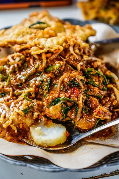 stock image pecel dish consisting of mixed vegetables with peanut sauce and served with lontong rice, a typical Indonesian food concept.