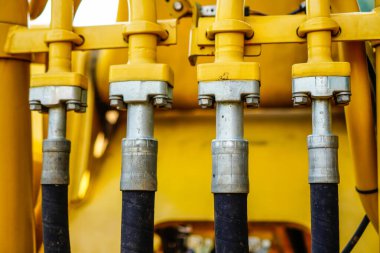 Güçlendirici cıvatalar, borular, hortumlar, traktörler ya da diğer inşaat ekipmanlarıyla desteklenen nozül hortumunun yakın görüntüsü.