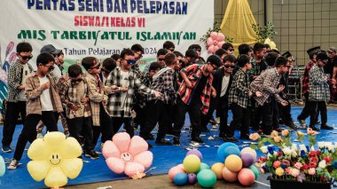 Serpong, Güney Tangerang, 19 Haziran 2024 - Altıncı sınıf öğrencilerinin serbest bırakılması için küçük çocukların sanat performansı. Endonezyaca.
