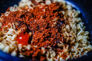 Eriştenin üzerine baharat serpiştirilmiş kızarmış eriştenin tam kare görüntüsü..