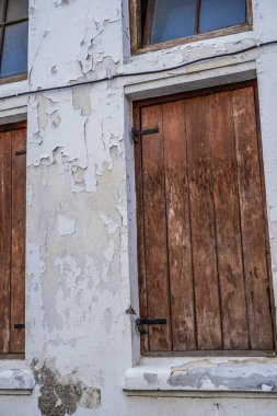 Duvarları soyulan eski bir binanın ahşap pencereleri..