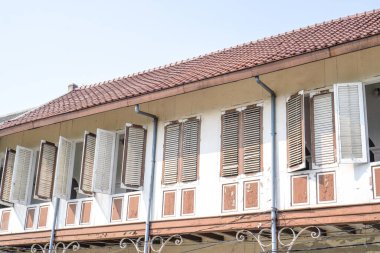 Balkonları ve gökyüzüne bakan bir sürü penceresi olan, reklam için boş yeri olan klasik eski bir bina..