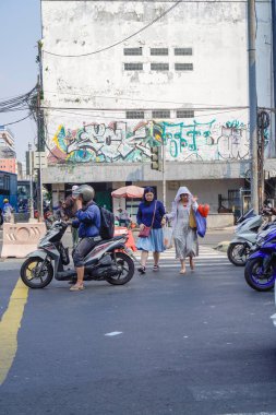 Eski Jakarta şehri, 20 Temmuz 2024 - eski Jakarta şehrinin caddelerinden geçen yayalar.