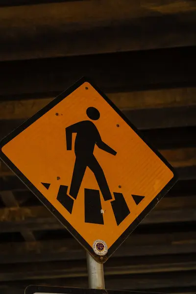 stock image traffic sign for pedestrian crossing, close up view of yellow traffic sign for pedestrians crossing the road.