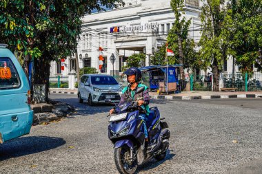 Ancol, Kuzey Jakarta, 10 Ağustos 2024, Ancol, Kuzey Jakarta 'daki tren istasyonunun önünden dönen sürücülerin bulunduğu kavisli bir yol manzarası..