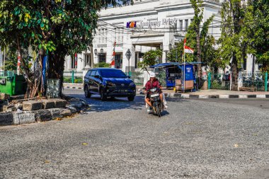 Ancol, Kuzey Jakarta, 10 Ağustos 2024, Ancol, Kuzey Jakarta 'daki tren istasyonunun önünden dönen sürücülerin bulunduğu kavisli bir yol manzarası..