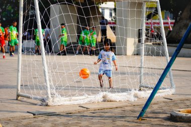 Pamulang, Güney Tangerang, 9 Ağustos 2024, kalede tek başına top oynayan küçük çocuk, kalenin arkasından bakıyor..