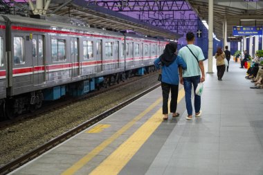 Elektrikli tren istasyonunda el ele tutuşan bir çift. Elektrikli trenden inen bir çift kavramı..