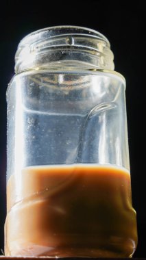 Tahta masaya izole edilmiş sütlü kahve bardağı fotokopi alanı için siyah arka planda pürüzsüz asfalt bırakıyor..