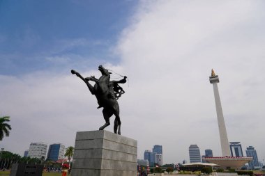 Prens Diponegoro 'nun at süren heykeli, Endonezya Ulusal Anıtı' nın arka planına, gökyüzünün reklam alanı olarak kurulmuştur..