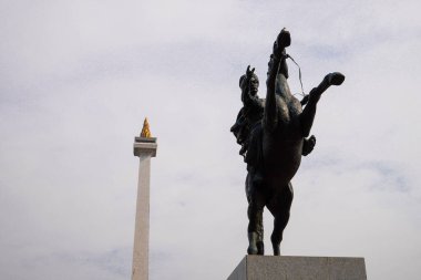 Prens Diponegoro 'nun at süren heykeli, Endonezya Ulusal Anıtı' nın arka planına, gökyüzünün reklam alanı olarak kurulmuştur..