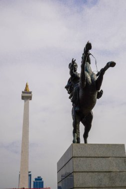 Prens Diponegoro 'nun at süren heykeli, Endonezya Ulusal Anıtı' nın arka planına, gökyüzünün reklam alanı olarak kurulmuştur..