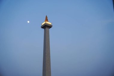 Jakarta, 17 Ağustos 2024, mavi gökyüzünde Ay 'ın arka planında yanan bir meşale şeklindeki anıt..