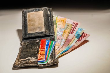 Cüzdandaki Endonezya banknotları beyaz, rupiah banknotları siyah cüzdanda. Cüzdanına sıkıştırılmış bir deste kart..