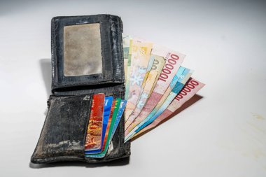 Cüzdandaki Endonezya banknotları beyaz, rupiah banknotları siyah cüzdanda. Cüzdanına sıkıştırılmış bir deste kart..