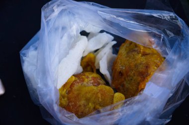 Plastik torbaya izole edilmiş kızarmış tofu yakın çekim. Siyah arka planda kızarmış tofu..