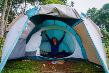 Asyalı adam tatilde kamp çadırında uyuduktan sonra uyandı..