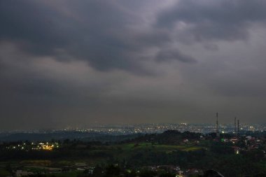 Sabahın erken saatlerinde kırsal köy ışıklarının arka planıyla dağın tepesinden manzara.