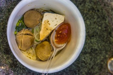 Bir kase köfte, tofu ve erişte çorbası, lezzetli Asya yemekleri, erişteli köfteler ve bir kapta tofu..