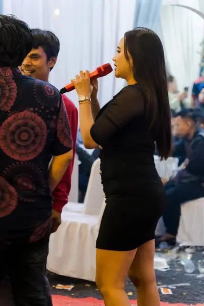 Jakarta, 2 Kasım 2024, Asyalı insanlar partide dans ediyor ve dans ediyor, seksi bir kadın dans etmekle meşgul bir adamla şarkı söylüyor..