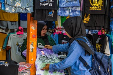 Merkez Cakarta, 25 Aralık 2024 'te peçeli bir kadın mağazadaki kıyafetlere baktı. Marketten kıyafet seçen Müslüman bir kadın..