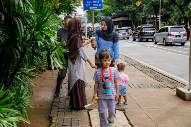 Merkez Jakarta, 25 Aralık 2024, tatildeki aileler, şehir sokaklarında yürüyorlar.
