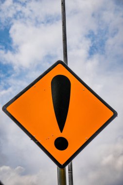 Gökyüzü arka planında reklam alanı tabelası olan yol tabelası. Ünlem işareti trafik işaretinde izole edildi.