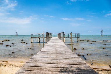 Deniz kıyısındaki ahşap iskele. Fotokopi alanı için gökyüzü arka planı temiz. Deniz kıyısındaki ahşap iskele.