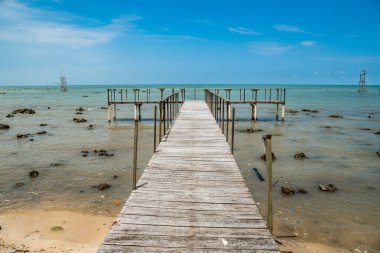 Deniz kıyısındaki ahşap iskele. Fotokopi alanı için gökyüzü arka planı temiz. Deniz kıyısındaki ahşap iskele.