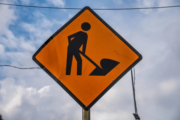 İnşaat alanı tabela tabela DANGER, konsept resim yapım aşamasında, yol üzerinde mavi gökyüzü olan yol tabelası kopya alanı için.