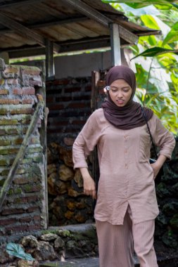 Cava kadınları eski evden çıkarken peçe takıyor.